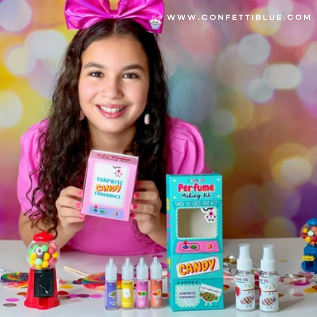 Girl with pink shirt and pink bow holding a Confetti Blue Candy Scented Perfume Making Kit for Kids with scents and fragrances on display and surprise candy fragrance